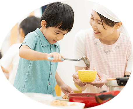 給食の配膳を手伝う園児